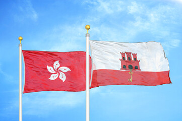 Hong Kong and Gibraltar two flags on flagpoles and blue cloudy sky