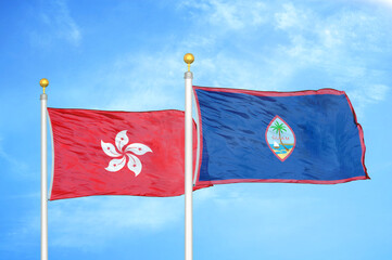 Hong Kong and Guam two flags on flagpoles and blue cloudy sky