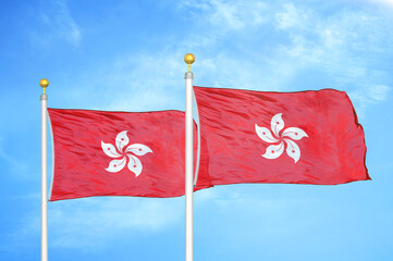Hong Kong two flags on flagpoles and blue cloudy sky