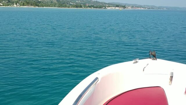 Front part of a speedboat in a natural port in the region of Halkidiki Greece, turquoise calm water and blue summer sky
