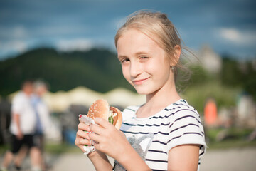 young girl eating hamburger