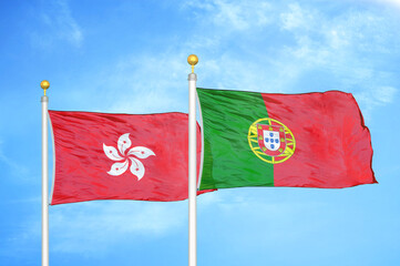 Hong Kong and Portugal two flags on flagpoles and blue cloudy sky