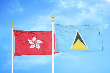 Hong Kong and Saint Lucia two flags on flagpoles and blue cloudy sky
