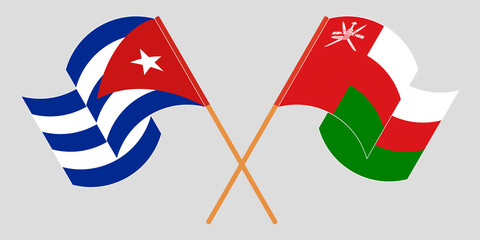Crossed and waving flags of Cuba and Oman