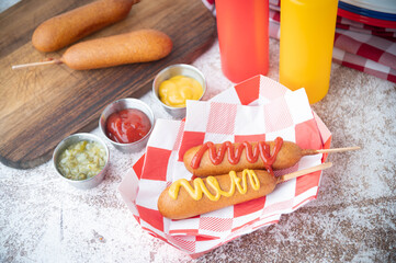 corn dog with ketchup and yellow mustard