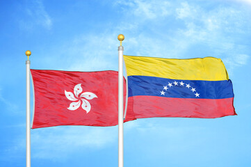 Hong Kong and Venezuela two flags on flagpoles and blue cloudy sky