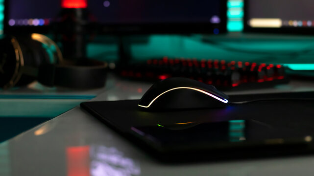 Computer mouse with neon illumination on a white glossy table, dark room, neon light, diodes. Gaming devices, neon lights, white glossy table. Lifestyle, game zone.