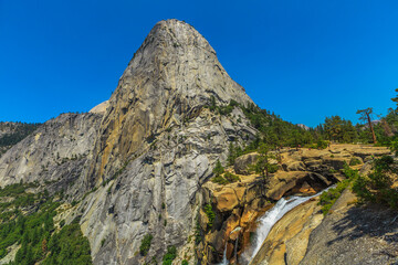 Panorama of Liberty Cap and Nevada Fall waterfall on Merced River from John Muir trail in Yosemite National Park. Summer travel holidays in California, United States of America.