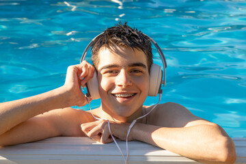 young boy or teenager with headphones in the pool