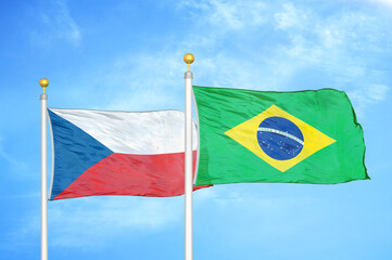 Czech and Brazil two flags on flagpoles and blue cloudy sky