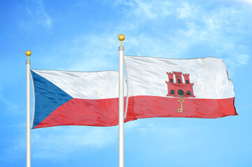 Czech and Gibraltar two flags on flagpoles and blue cloudy sky
