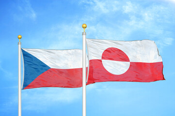 Czech and Greenland two flags on flagpoles and blue cloudy sky