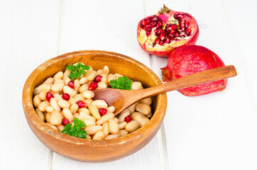 Dish with white beans and pomegranate seeds.