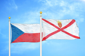 Czech and Jersey two flags on flagpoles and blue cloudy sky