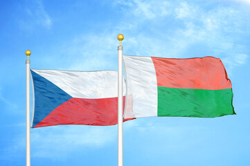 Czech and Madagascar two flags on flagpoles and blue cloudy sky