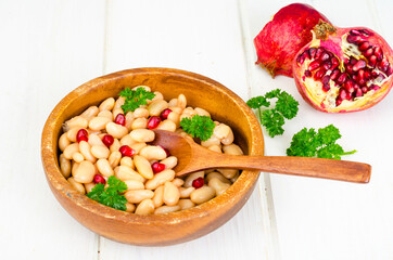 Dish with white beans and pomegranate seeds.