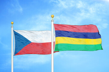 Czech and Mauritius two flags on flagpoles and blue cloudy sky