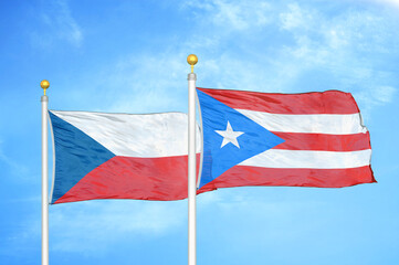 Czech and Puerto Rico two flags on flagpoles and blue cloudy sky