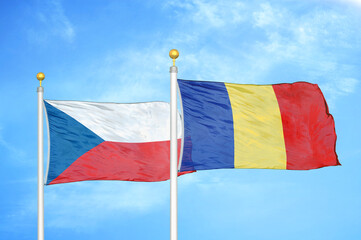 Czech and Romania two flags on flagpoles and blue cloudy sky
