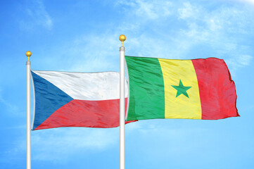 Czech and Senegal two flags on flagpoles and blue cloudy sky