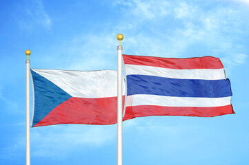 Czech and Thailand two flags on flagpoles and blue cloudy sky