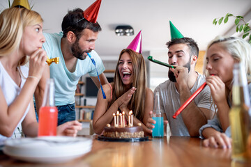 Group of friends celebrating birthday at home.