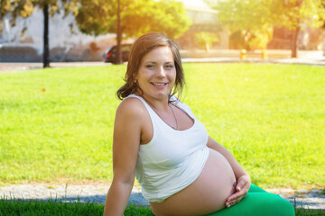 Close up of pregnant belly in nature in a city park