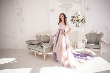 Bride in color wedding dress. Beautiful model in a beautiful wedding dress in a white photo studio. Portrait of an attractive girl in a beautiful interior.