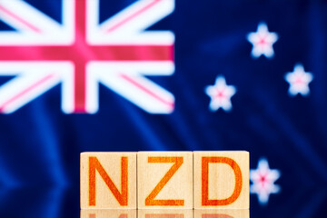 nzd concept. wooden blocks with the inscription nzd on background Flag of New Zealand