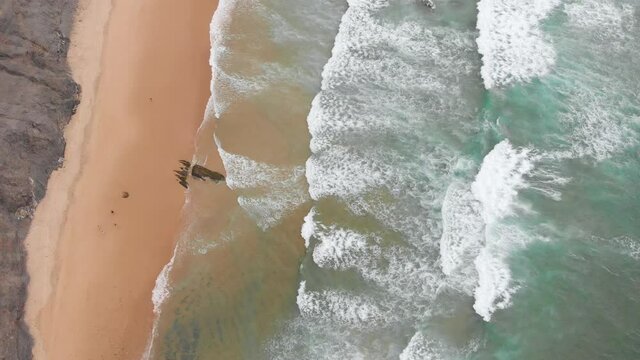 Aerial drone view of waves breaking on the beach ocean coastline waves sea.