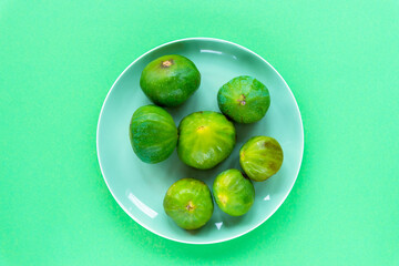 Green figs on a plate, top view, flat lay. Healthy raw vegan food