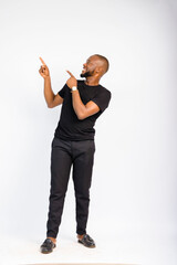 young black handsome man standing and pointing at something towards his top right corner