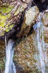 Small creek waterfall by large rocks on hike in Virginia forest mountains in winter