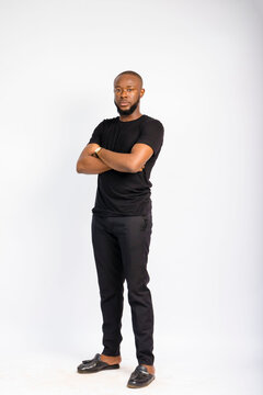 young black handsome man standing and folding his arms in front of a white background