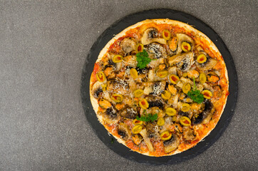 Pizza with mussels, mushrooms, green olives