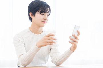 スマホを見る女性　飲み物