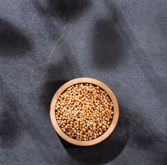 Sinapis alba - Yellow mustard grains in the wooden bowl
