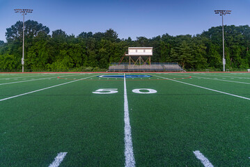Fototapeta premium Orange High School Track and Green Artificial Football Field Early Morning