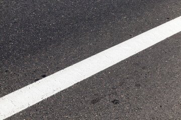close-up of an asphalt road with white road markings