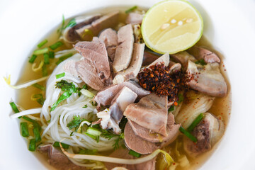 vermicelli noodles soup spicy with pork stew vegetable and lemon in bowl traditional thai and chinese style food of asia , Pork offal , Liver pork intestines - delicious noodles bowl