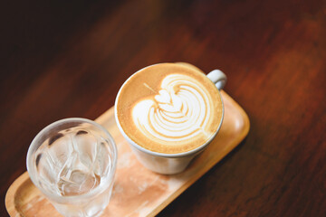 cappuccino latte art hot coffee on wooden table background - coffee cup top view