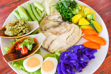 Steamed fish with chili sauce boiled eggs and vegetables pumpkin carrot on white plate - Thailand food Asian cooked tilapia fish