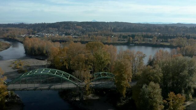 traffic over green steele bridge and shot of the river behind it