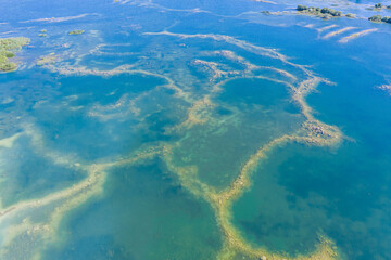 Aerial view of a shallow turquoise lake with a raised sandy bottom