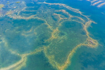 Aerial view of a shallow turquoise lake with a raised sandy bottom