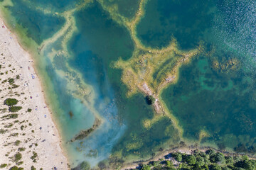 Aerial view of a shallow turquoise lake with a raised sandy bottom