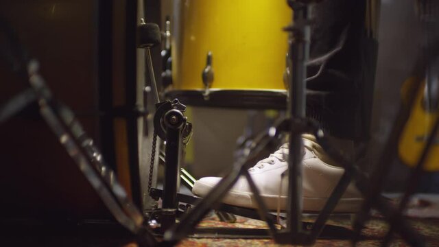 Unrecognizable musician using bass drum beater pedal while playing drums, close-up shot of his foot