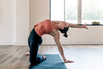 woman holding yoga pose in gym