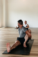 Fototapeta na wymiar Man and woman stretching in yoga class