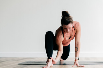 Woman doing yoga and stretching in a white studio